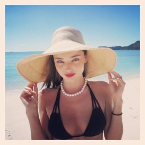 Woman modelling accessories - sun hat and pearls.