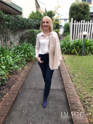 Woman wears a ivory coloured Zara blouse with navy Betty Barclay jeans.