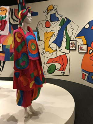 Mannequin wears an bright, bold outfit featuring large rounded shapes.