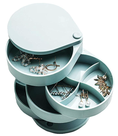 A duck-egg blue coloured rotating jewellery box. There are a few pairs of earrings in the box.