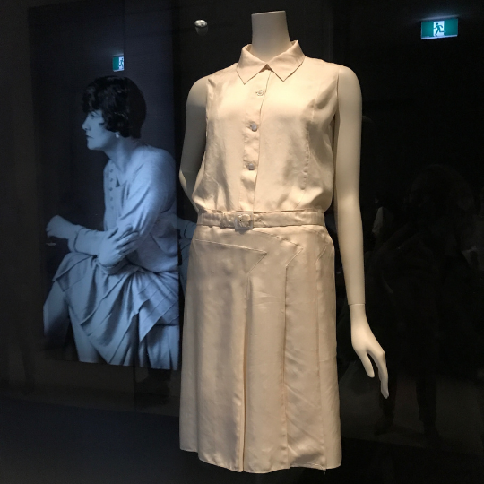 This Chanel soft white sportswear ensemble consists of a sleeveless, collared blouse and a straight skirt with distinctive 'arrow-like' details on the front.